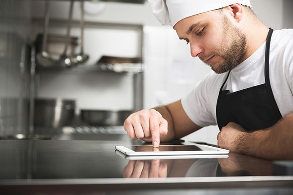 chef in kitchen with tablet